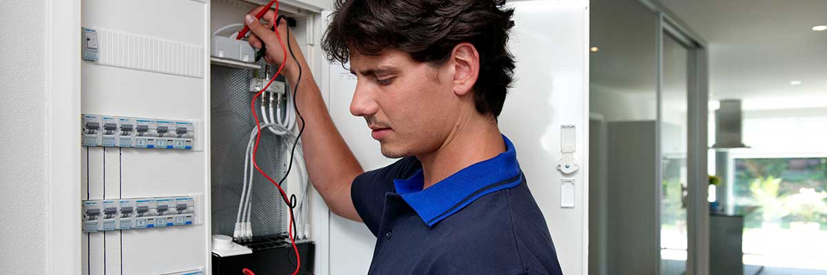 Elektriker kontrolliert Elektroinstallation am Tableau